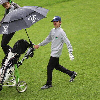 junger Golfer mit Trolley